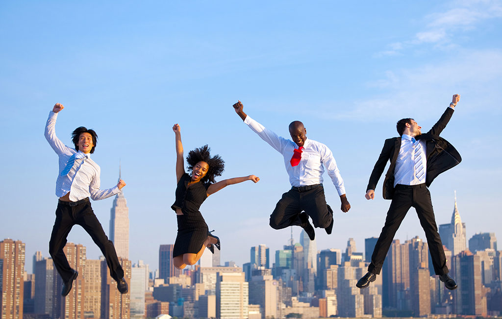 Happy successful business people celebrating by jumping in New York.